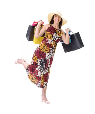 Güzel, gülümseyen genç bir kadın bir sürü alışveriş çantasıyla poz veriyor, beyaz arka planda duruyor..