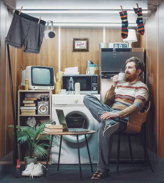 Küçük stüdyo dairesinde kahve içen mutlu bir adamın portresi.