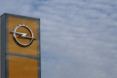 Polonya, Poznan - 30 Ekim 2022: Araba galerisi alanının dışında bulutlu mavi bir gökyüzüne karşı Opel logosu. Alman uluslararası otomobil üreticisinin sembolüdür.