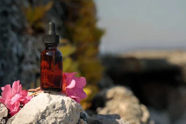 Medicines from Bach flowers, bottle with dropper in natural setting. Mock-up. Beautiful flower mockup for presentation of cosmetic, medical produc.