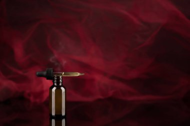 Therapeutic preparation in a dropper for various sexual health problems. Drip bottle with red background.