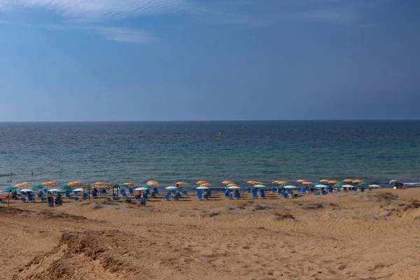 Korfu adasının kumlu plajı, şemsiyeleri ve sandalyeleri..