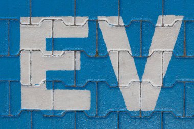 Mavi kaldırımda 'EV' sembolüyle işaretlenmiş park yeri. Bu da elektrikli araçlar için şarj istasyonu anlamına geliyor..