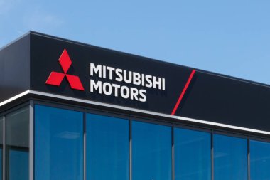 Polonya, Przezmierowo - 27 Temmuz 2023: Mitsubishi Motors logosunu bir bayilik binasının karanlık cephesinde gösteren bir tabela. Mitsubishi Grubu, otomobil üretimi ve otomobil üretimi ile tanınan otonom Japon şirketlerinden oluşan ünlü bir holdingdir.