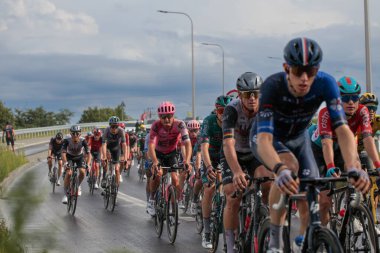 Polonya, Plewiska - 29 Temmuz 2023: Tour de Pologne. Polonya 'da düzenlenen uluslararası bisiklet yarışı Pologne Turu' nun ilk etabının sonunda çekilen yakın plan çekimde, bir pelotonda profesyonel bisikletçiler yer alıyor..
