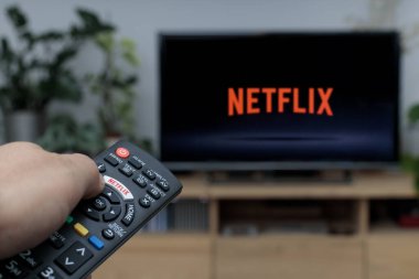 Polonya, Leszno - 23 Kasım 2021: Netflix logosuyla uzaktan kumandayı tutmak