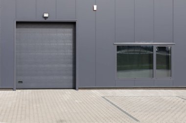 Gri endüstriyel duvar. Kapısı ve penceresi perdeli. Modern Endüstriyel İnşaat Cephesi