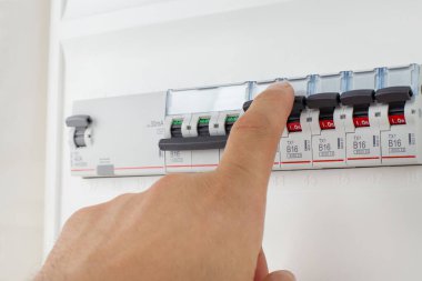 Hand Adjusting Circuit Breakers on Panel clipart