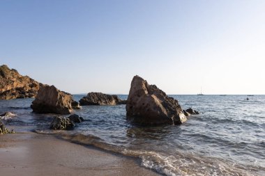 Gün batımında Yumuşak Dalgalarla Rocky Shoreline