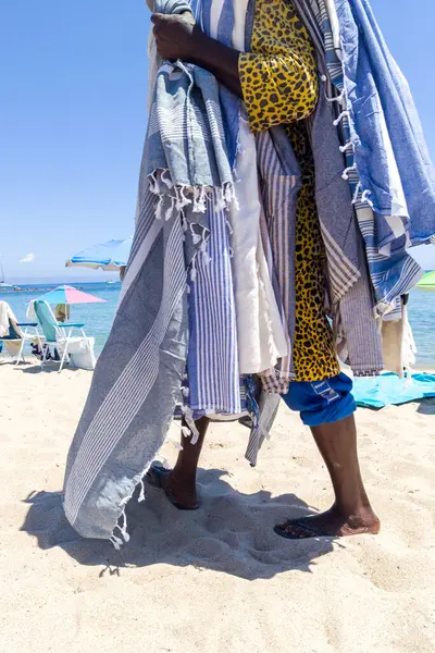 stock image Beach Vendor Draped in Colorful Towels on Sandy Shore