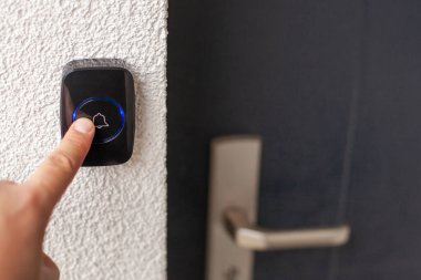 Beyaz Duvarda Mavi Halkalı Siyah Kapı Çanı