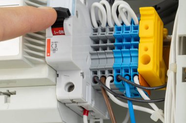 Paneldeki elektrik şalterini açan el.
