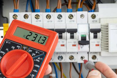 Hand Testing Electrical Circuit with Multimeter clipart