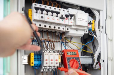 Paneldeki Elektrik Testi için Eller Çokölçer Kullanılıyor