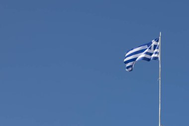 Yunan bayrağı sallayarak karşı mavi gökyüzü