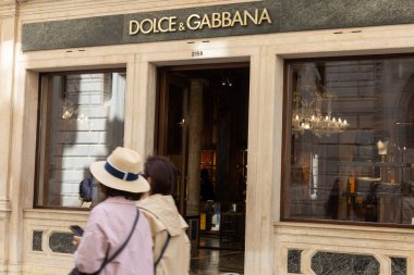 Venedik, İtalya - 19 Nisan 2025: Venedik 'te Dolce ve Gabbana lüks butiği önünden geçen insanlar