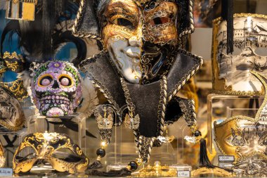 Venedik, İtalya - 17 Nisan 2025: Yerel mağaza vitrininde ayrıntılı Venedik maskeleri ve kafatası resimleri gösterimi