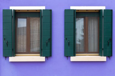 Mor duvarda iki yeşil pencereli