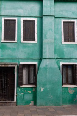 Burano İtalya 'da koyu renk panjurlu eski yeşil bir ev.