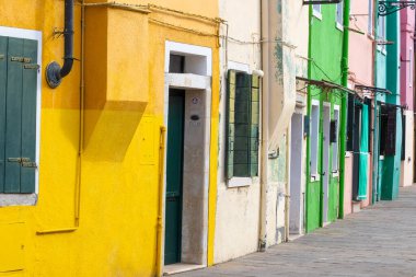 Burano İtalya 'da yeşil panjurlu renkli eski evler