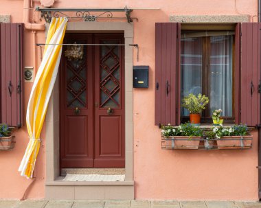 Burano İtalya 'da kırmızı panjurlu renkli ev cephesi