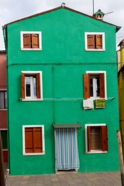 Burano İtalya 'da ahşap panjurlu parlak yeşil bir ev.