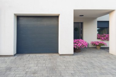 Çiçek saksıları ve garajı olan Modern Ev Girişi