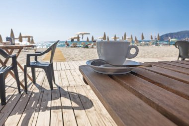 Güneşli sahil terasında beyaz kahve fincanı.