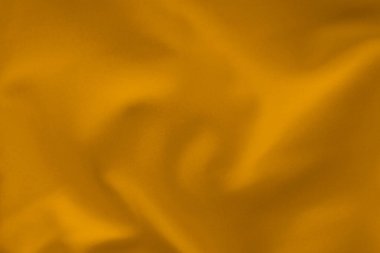 Yumuşak kıvrımlı hardal sarısı kumaş, tekstil deseni yakın plan.