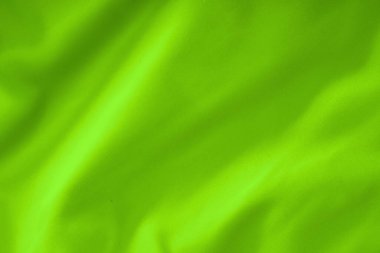 Yumuşak kıvrımlı neon yeşil kumaş, tekstil dokusu yakın plan.