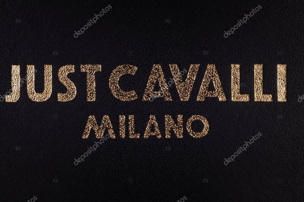 Leszno, Poland - July 10 2025: Just Cavalli Milano golden embossed logo on black leather