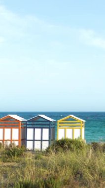 Famous wooden beach cabins in Sagaro with Playa de Sant Pol, Costa Brava. Spain. Mediterranean Sea. The bathing huts date from the early 1920s. Vertical video