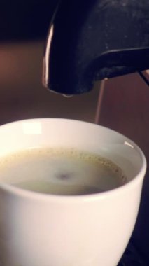 Yavaş kahvaltı sahnesi. Kahve makinesi kahvaltıda fincana taze espresso dolduruyor. 240 fps görüntü. dikey video