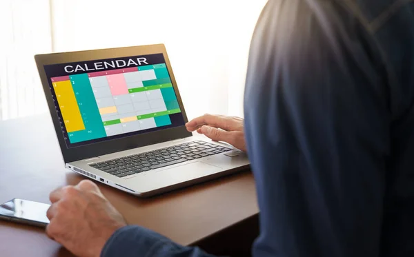 Worker in an office with Calendar software showing busy schedule of manager with many meetings, tasks and appointments during the week. Time blocking and management organization at work concept
