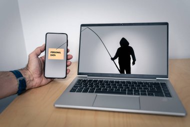 Dizüstü bilgisayarında olta tutan bir bilgisayar korsanı silueti akıllı telefondan kişisel verileri çalıyor. Sahtecilik, yok etme, siber hırsız ve kişisel veri kaybı gibi kavramlar için uygun.