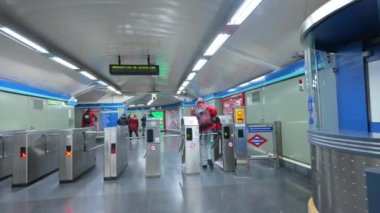 Madrid, İspanya. 6 Kasım 2023: Madrid, İspanya 'da metro istasyonundaki toplu taşıma aracıyla bir metro istasyonuna giren ve turnikelerden geçen yolcu
