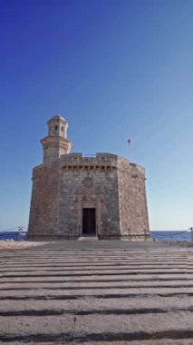Menorca adasındaki güzel Akdeniz kasabası Ciutadella 'daki Sant Nicolau Kalesi. Sant Nicolau Kalesi stratejik olarak Ciutadella limanının girişinde yer almaktadır. Dikey video