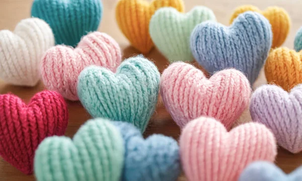Multicolored knitted hearts in pastel colors. Minimal style flat lay photo, Valentines Day, romantic relationship, love, wedding concept, top view card, tender pastel color.