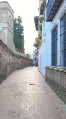 Santa Cruz 'un dar sokaklarında yürüyen bir turist. İspanya' nın Endülüs kentindeki Juderia ya da Sevilla 'nın Yahudi mahallesi olarak da bilinir. Dikey video