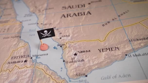 紅海地域の地図に海賊インシニアを取り囲む米国とイランの旗で飾られたピンを配置する それは象徴的に複雑な地政学的ダイナミクスを表しています — ストック動画