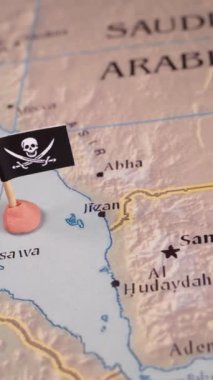 ABD ve İran 'ın bayraklarıyla süslenmiş el işaretleri Kızıl Deniz bölgesinin haritasında bir korsan amblemi oluşturuyor. Sembolik olarak karmaşık jeopolitik dinamikleri temsil eder.