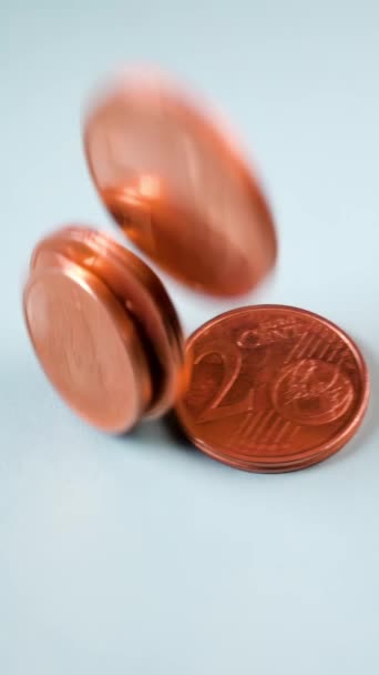 1ユーロと2ユーロのコインがゆっくりと流れていく ヨーロッパのコミュニケーションから1セント硬貨と2セント硬貨の現金支払いと流通のためのユニフォームラウンドルールに適しています バーティカル — ストック動画