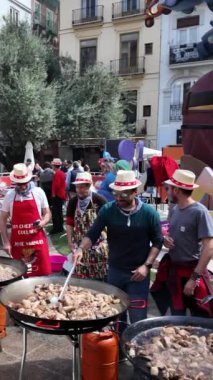 Valencia, İspanya, Mart 2024: Valencia 'daki Fallas şenlikleri sırasında sokakta toplu paellalar pişiren bir grup insan.