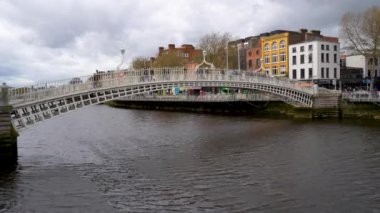 Dublin, İrlanda 'daki tarihi Ha penny Köprüsü. Liffey Nehri' nden geçen ikonik bir yaya. Ayırt edici dökme demir yapısı ile şehrin hareketli sokaklarına büyüleyici bir kapı görevi görüyor.