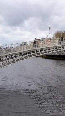 Dublin, İrlanda 'daki tarihi Ha penny Köprüsü. Liffey Nehri' nden geçen ikonik bir yaya. Ayırt edici dökme demir yapısı ile şehrin hareketli sokaklarına büyüleyici bir kapı görevi görüyor.