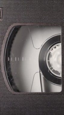 Bir VHS kaseti, bir VCR oynatıcıya, nostaljik ve retro medyaya yakın görüntüle. Kusursuz döngü ve kopyalama alanı, dikey görüntüler