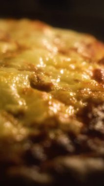 Fırın ısısından erimiş peynirli ev yapımı taze bir pizzanın yakın çekimi. Seçici odak ve dikey video