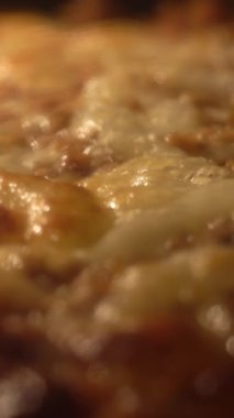 Fırın ısısından erimiş peynirli ev yapımı taze bir pizzanın yakın çekimi. Seçici odak ve dikey video
