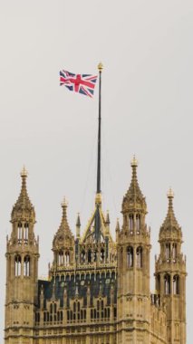 İngiliz mirasını, hükümetini ve ulusal gururu temsil eden Westminster Sarayı 'nın süslü kulelerinin üzerinde İngiliz bayrağı dalgalanmaktadır..