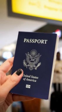 Havaalanı terminalinde elinde ABD pasaportu olan uluslararası seyahat ve gümrüğe hazır bir kadın..